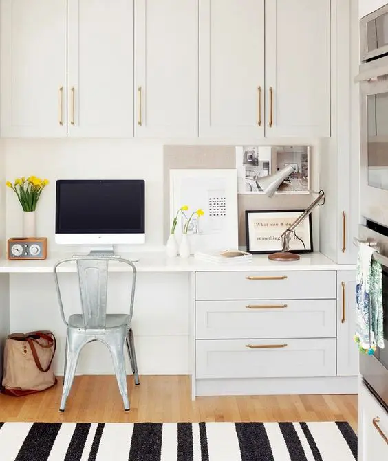 white kitchen with farmhouse metal chair, black and white striped rug, desk accessories, white cabinetry