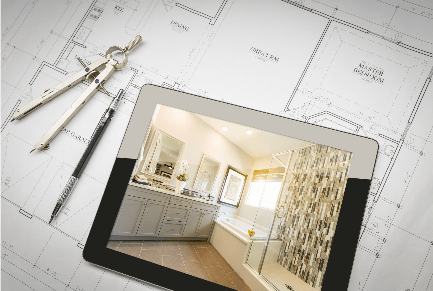a tablet with a finished bathroom laying on a set of renovation plans