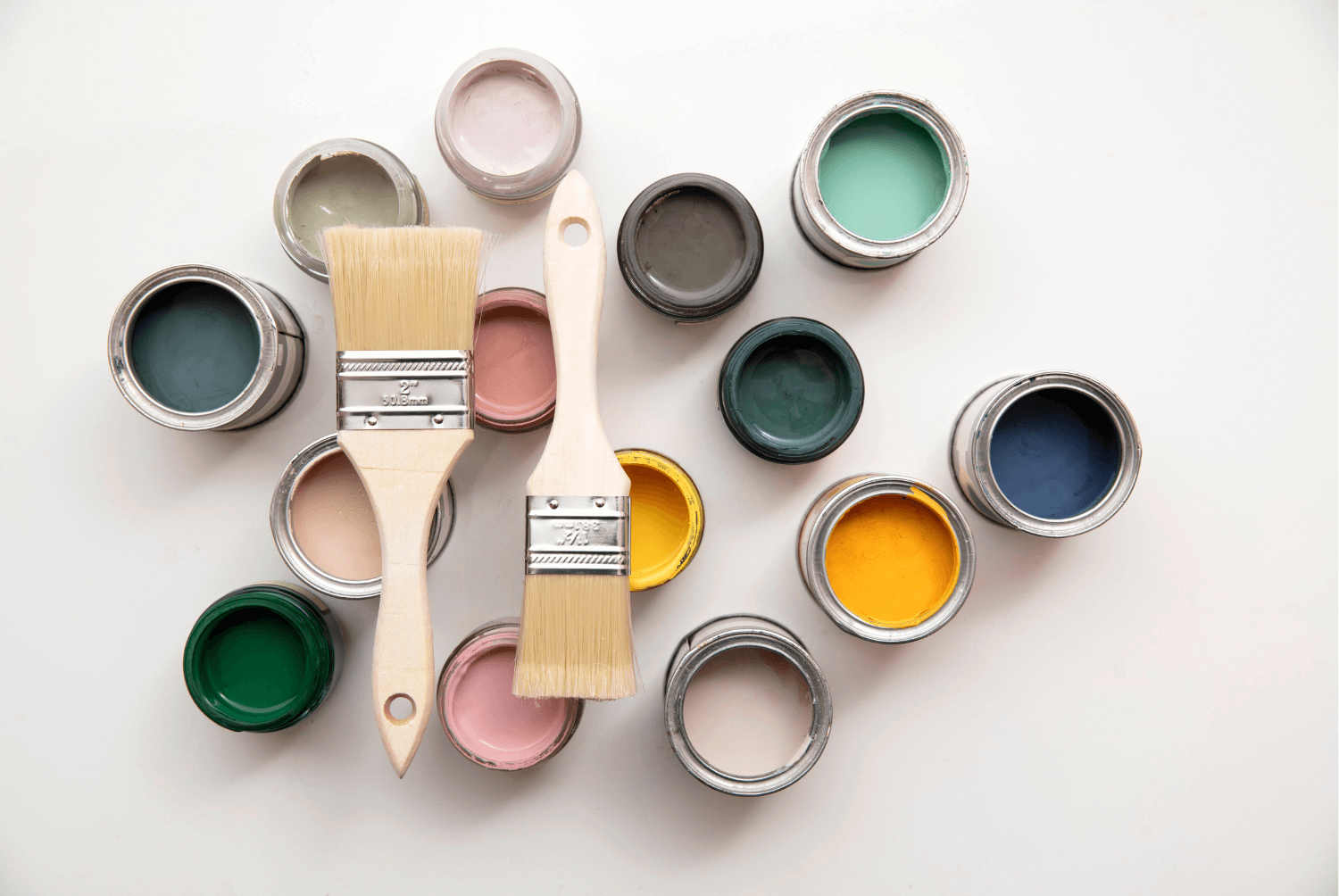 open paint cans with various colors of paint and 2 paint brushes