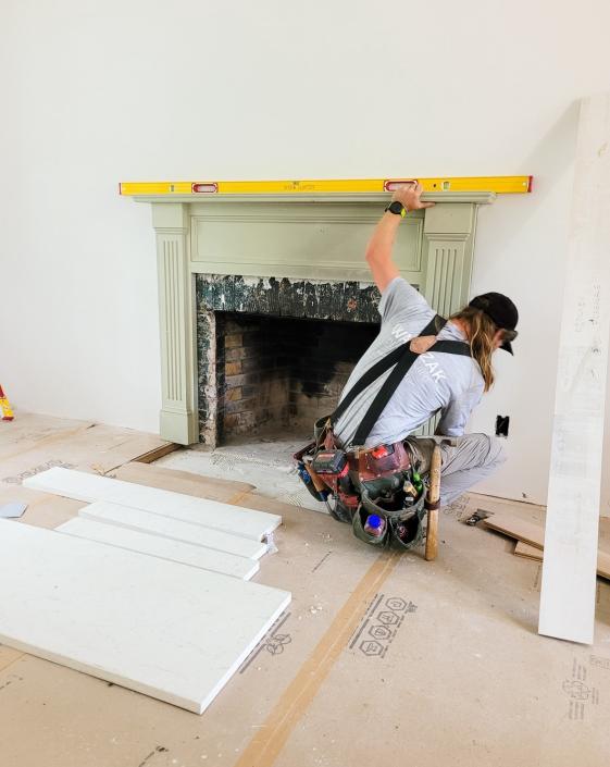 A worker checking the fireplace using a leveling equipment