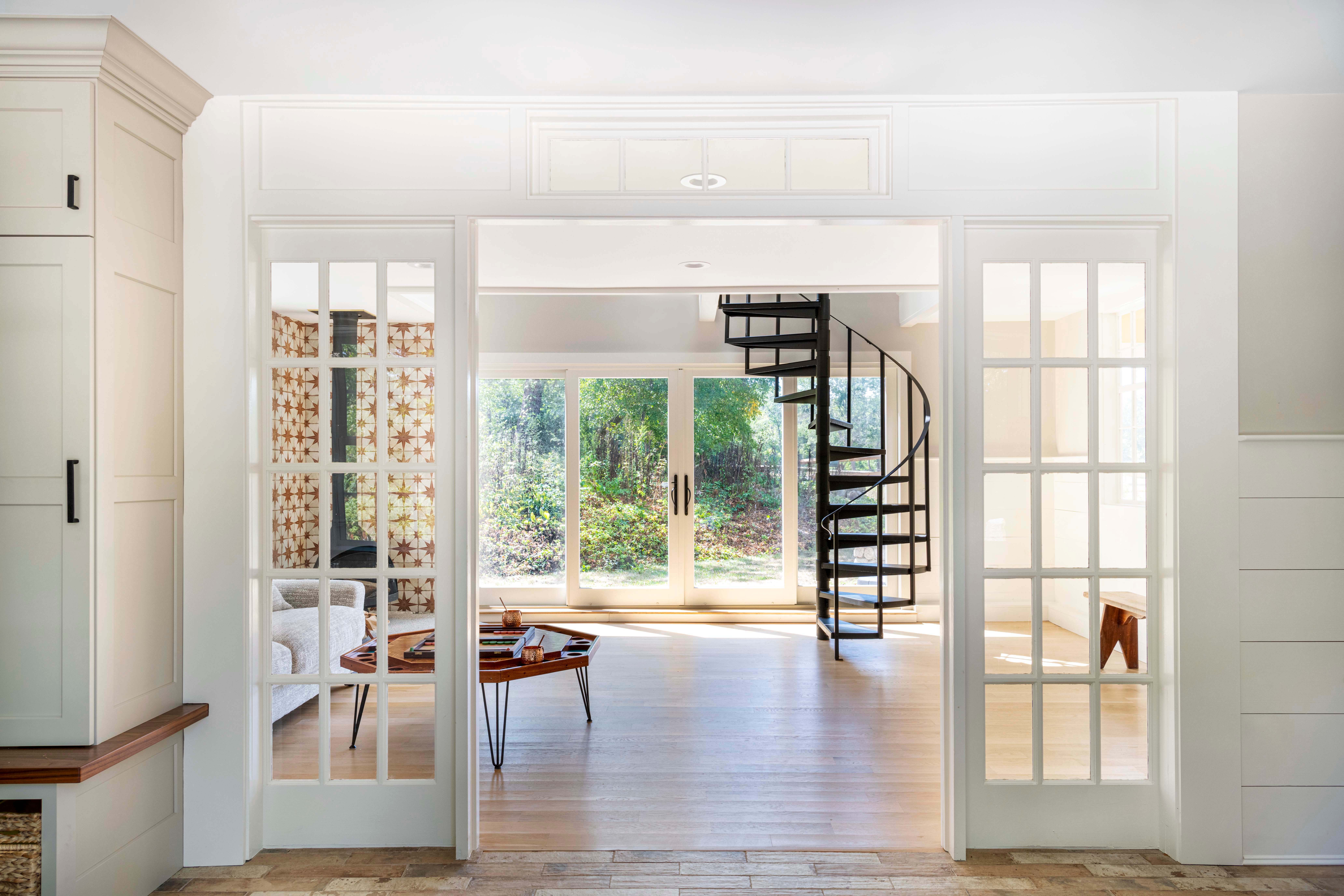 sun-drenched living room and mudroom, separated by french doors 