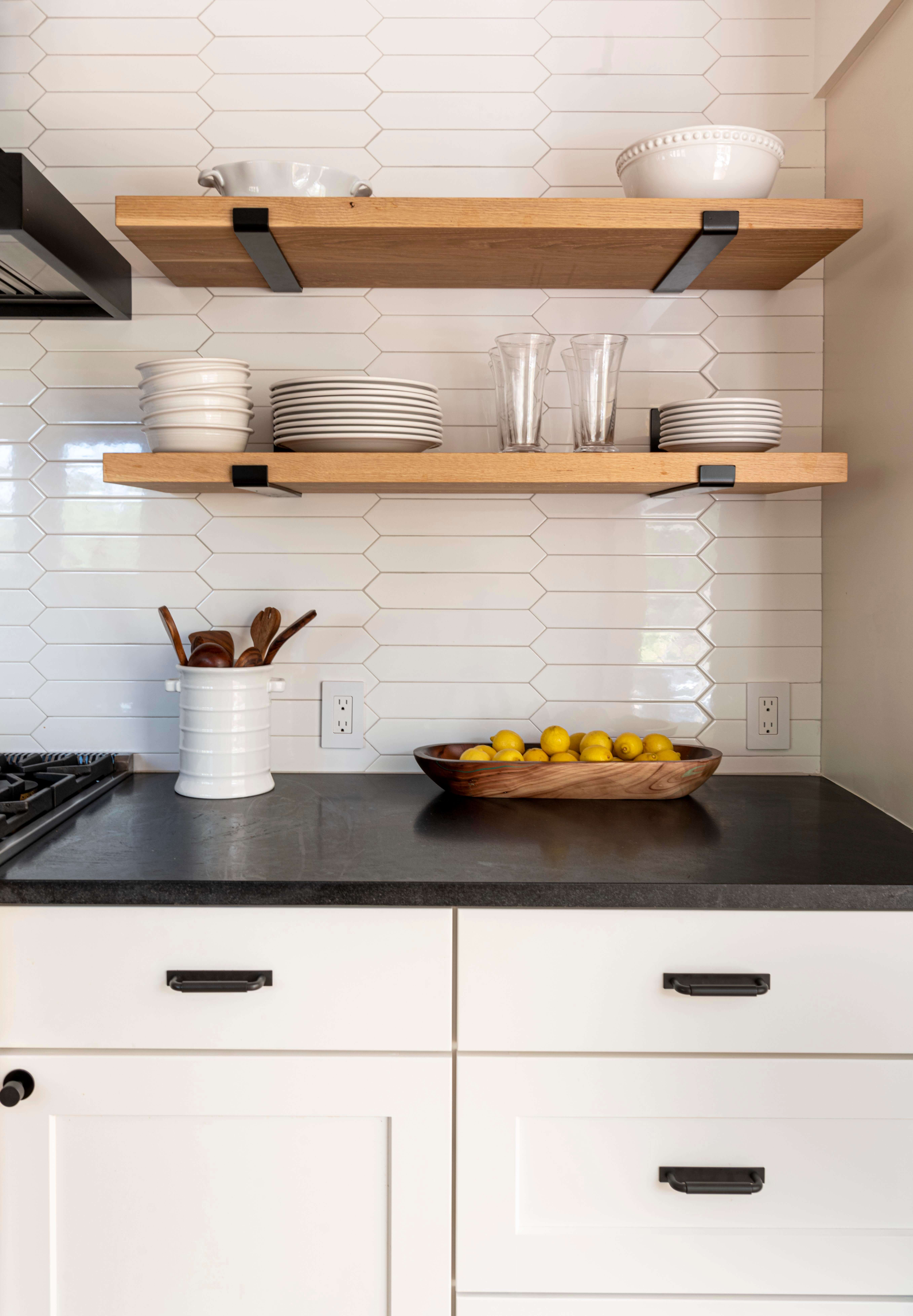 black granite countertop, white lower cabinetry, wood open shelving above