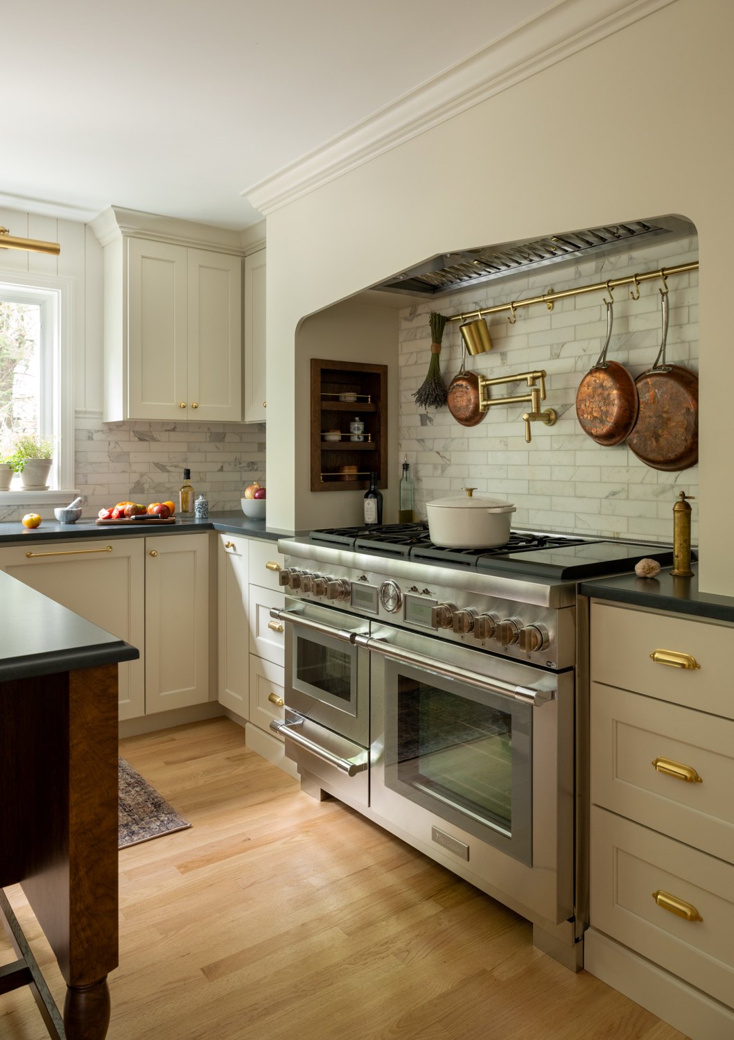 Double range set into an arched alcove with a marble-look porcelain surround and a pot filler