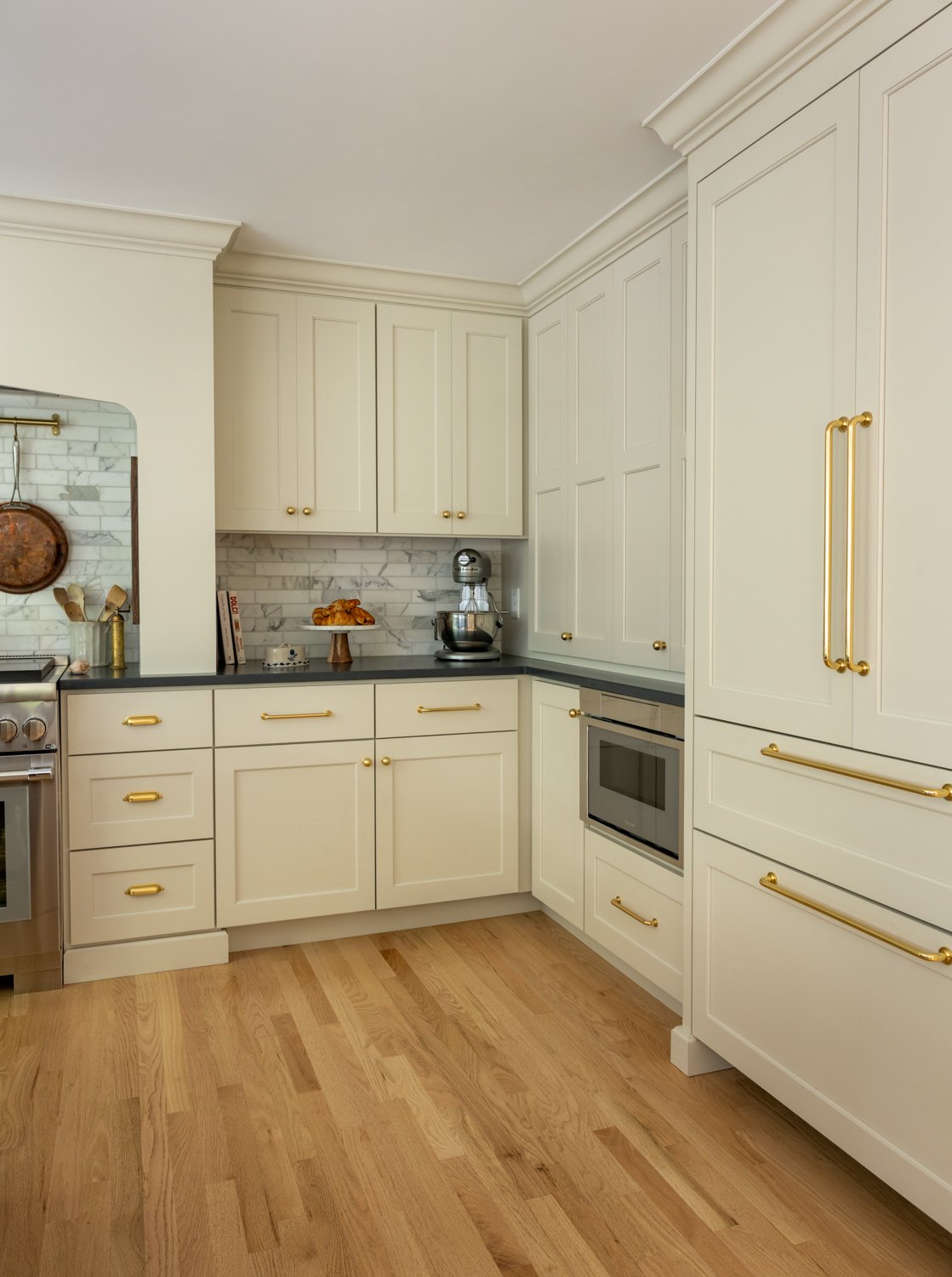 Corner of the kitchen with tall cabinets beside the range and a built-in oven