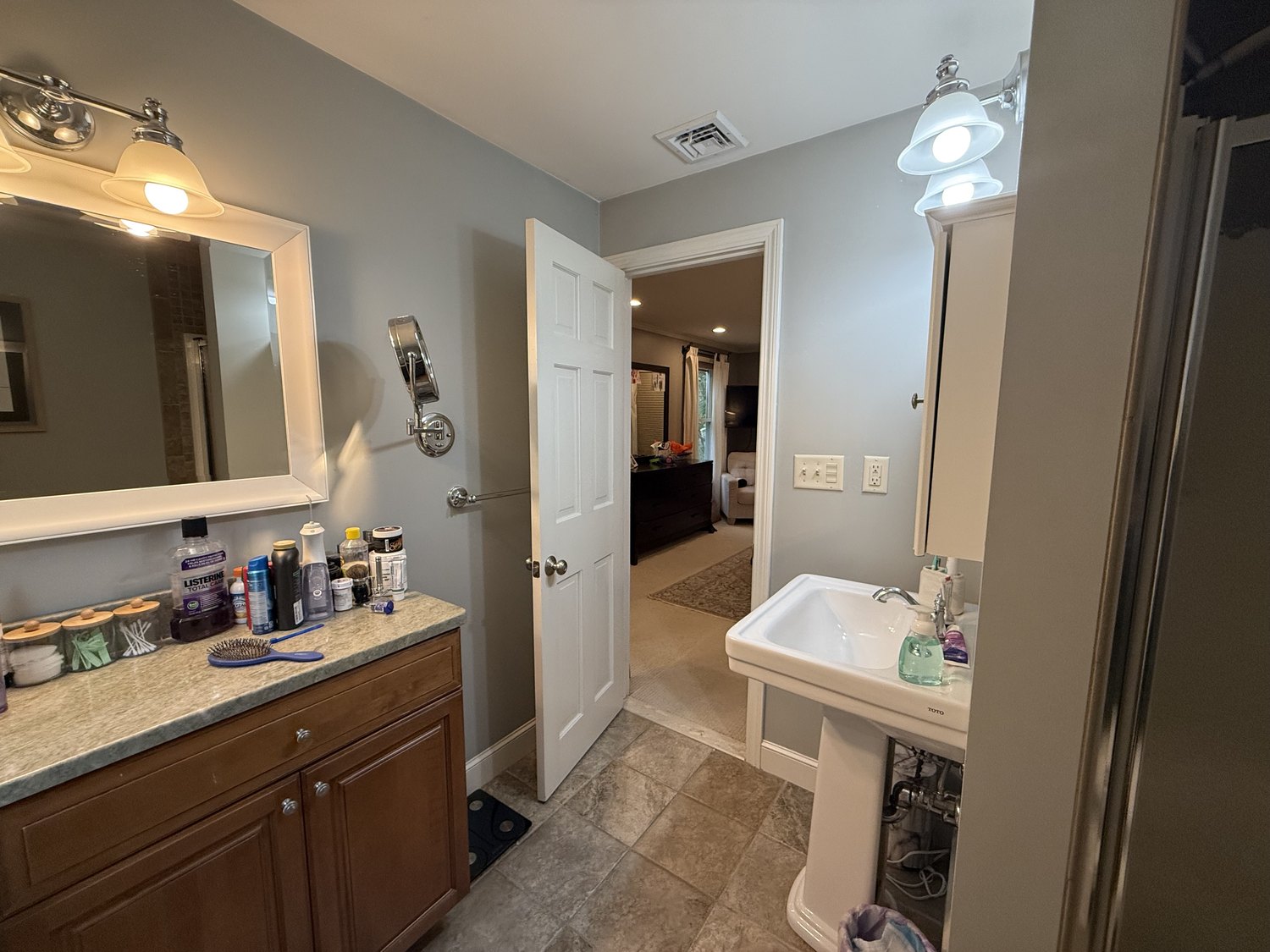 Original primary bathroom vanity with a large mirror and a doorway through to the pedestal sink