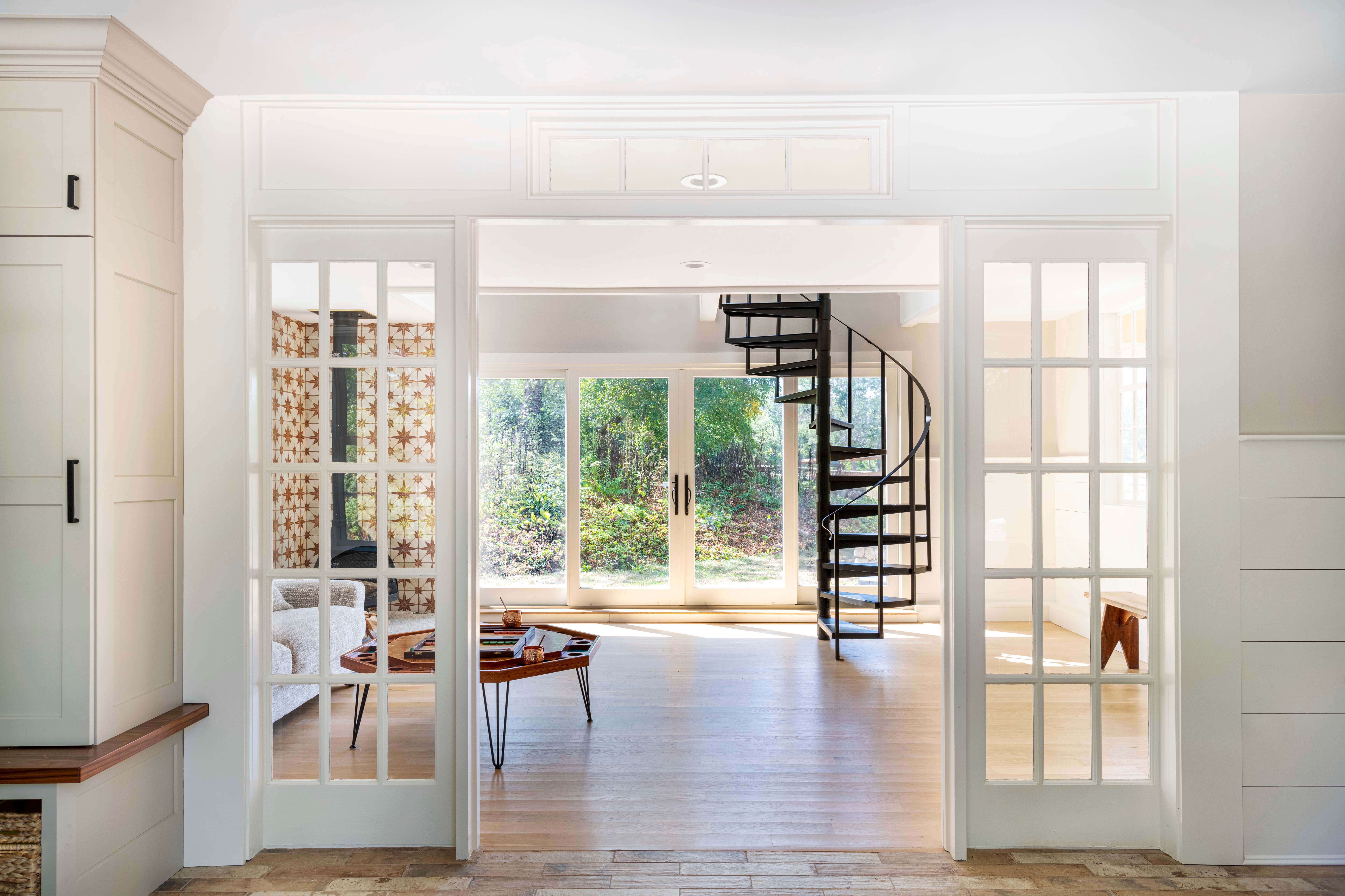 sun-drenched living room and mudroom, separated by french doors