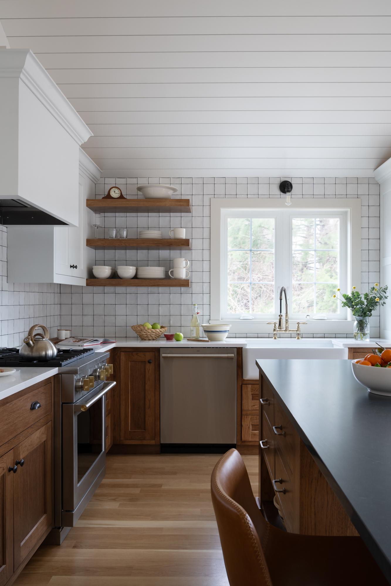 Galley ADU kitchen with a range, oak open shelving and white tile