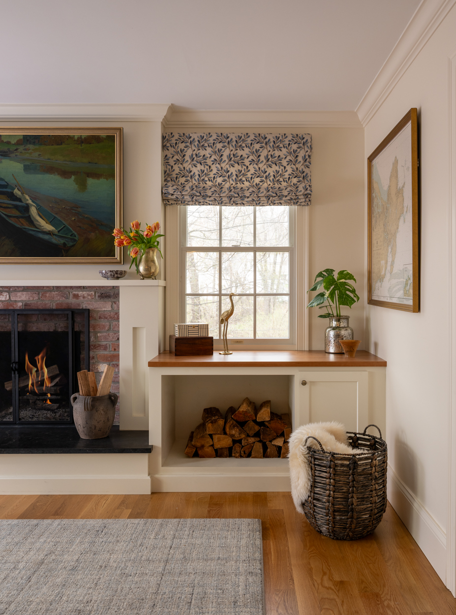 Fireplace with built in log storage and a framed painting above