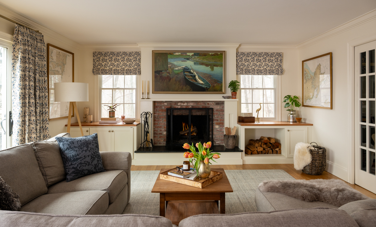 Living room with a fireplace, sofa and framed art above the mantel