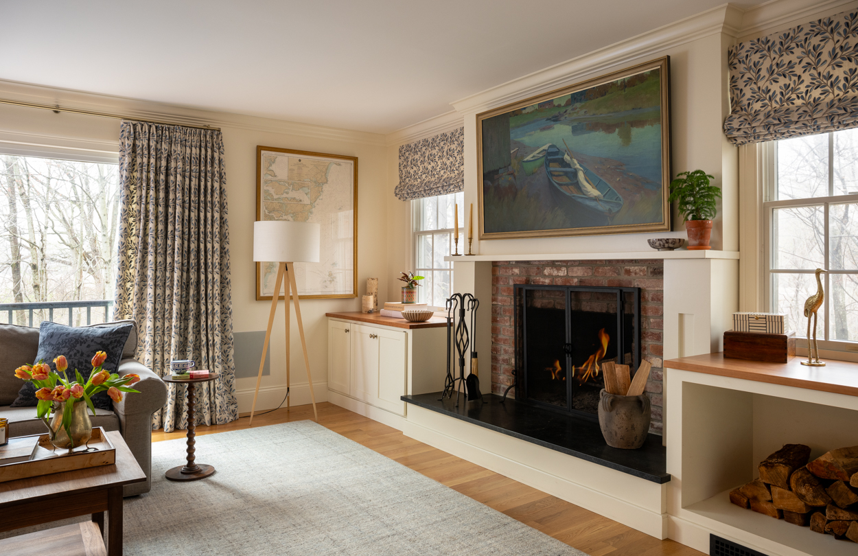 Living room with a fireplace flanked by windows and a patterned rug
