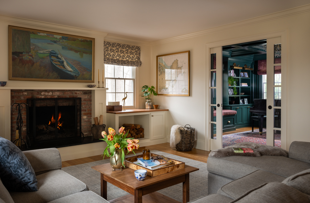 Living room with a sectional sofa, wood coffee table and a lit fireplace