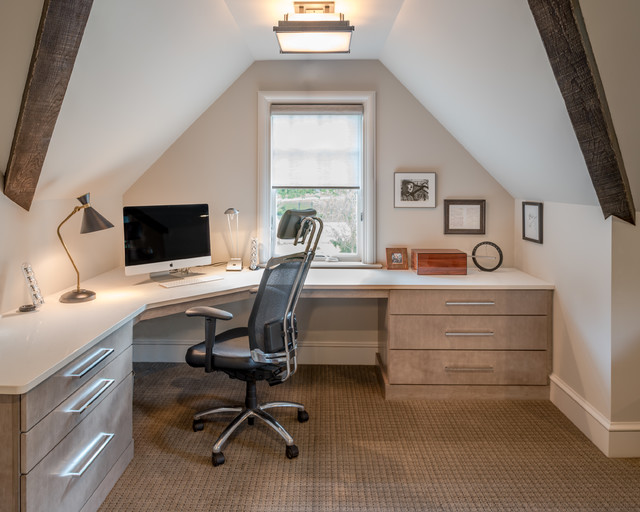 attic home office with natural wood cabinetry, photos and a black desk chair