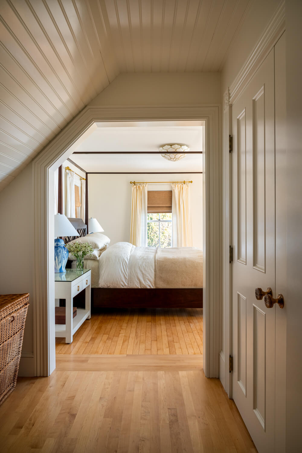 View along a hallway through an open doorway into a bedroom
